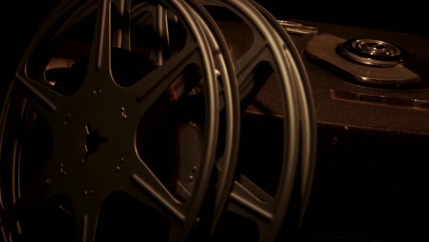 Pan over vintage movie camera and metal film reels