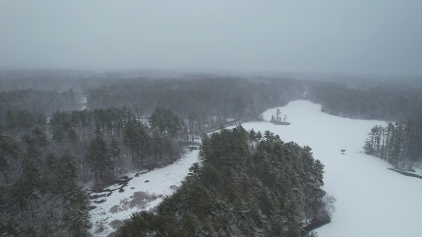 Snowy landscape during a winter storm in the United States, freezing temperatures near a lake in Massachusetts, Harold Parker State Forest