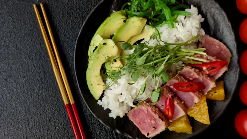 Seared tuna tataki in a bowl with sesame seeds, rice, and vegetables. Tuna tataki as a background for your design