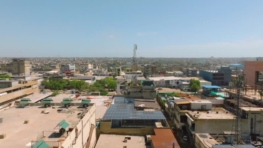 Sustainable energy in Karachi Pakistan showcasing solar panels installed on rooftops. aerial, push forward shot