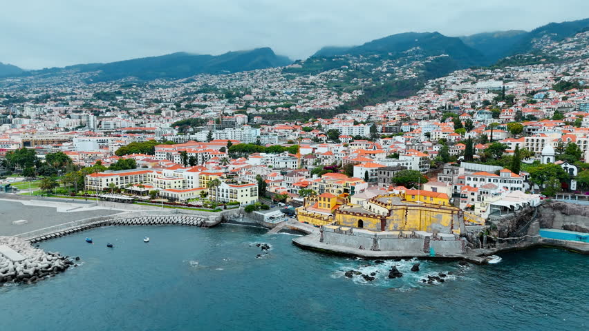 Drone shot of historic Sao Tiago Fortress into the coastal urban landscape of Funchal, Madeira
