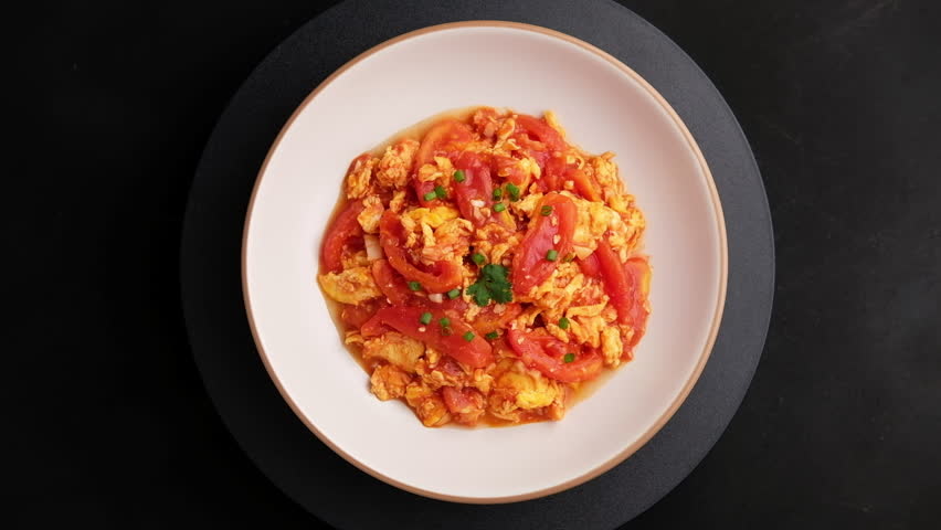 Stir fried egg with tomato,Scrambled eggs with tomatoes on white plate.Top view.