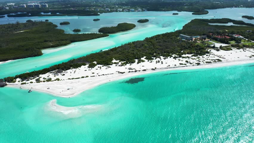 White sandy beaches stretch along aquamarine waters at Palmer Point Park. Captures the expansive coastal landscape. Suitable for travel features and nature documentaries.