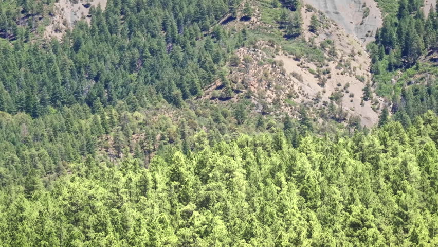 70mm cinematic aerial drone shot of Chimney Rock near Owl Creek Pass in Uncompahgre National Forest, near Pagosa Springs, Colorado, framed by rugged alpine terrain and jagged peaks.