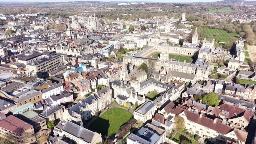 4K aerial video showing Oxford university architecture across a wide urban landscape in clear daylight.