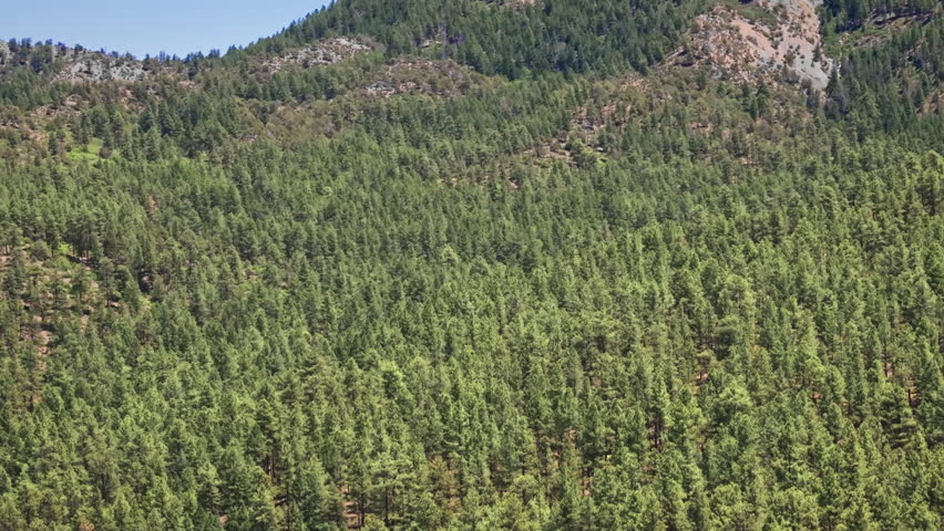 70mm cinematic aerial drone shot of Chimney Rock near Owl Creek Pass in Uncompahgre National Forest, near Pagosa Springs, Colorado, framed by rugged alpine terrain and jagged peaks.