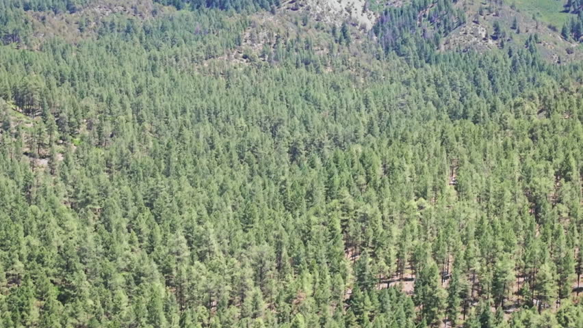 70mm cinematic aerial drone shot of Chimney Rock near Owl Creek Pass in Uncompahgre National Forest, near Pagosa Springs, Colorado, framed by rugged alpine terrain and jagged peaks.