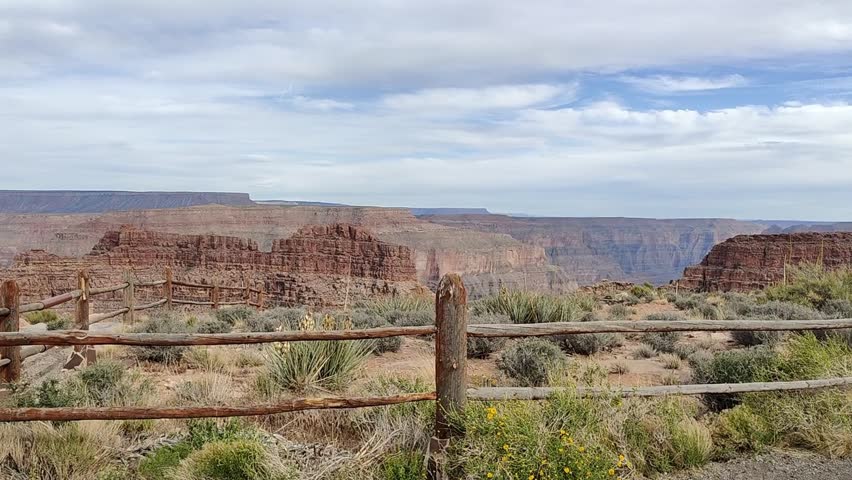 Scenic panoramic view of the Grand Canyon West Rim in Arizona, USA. Desert landscape with layered red rock cliffs, deep canyon formations, Colorado River view. A road trip near Eagle and Guano Point