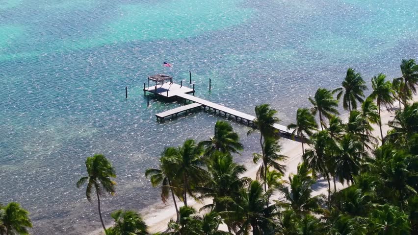 A sweeping aerial drone shot capturing the magnitude of the Seven Mile Bridge in the Florida Keys. The footage showcases the modern highway bridge alongside the historic old bridge as they cut through the crystal-clear, vibrant turquoise and emerald waters of the Atlantic Ocean and Gulf of Mexico. This high-altitude perspective emphasizes the isolation and engineering beauty of the Overseas Highway connecting Marathon to the Lower Keys. Ideal for travel documentaries, automotive commercials, and Florida tourism marketing.