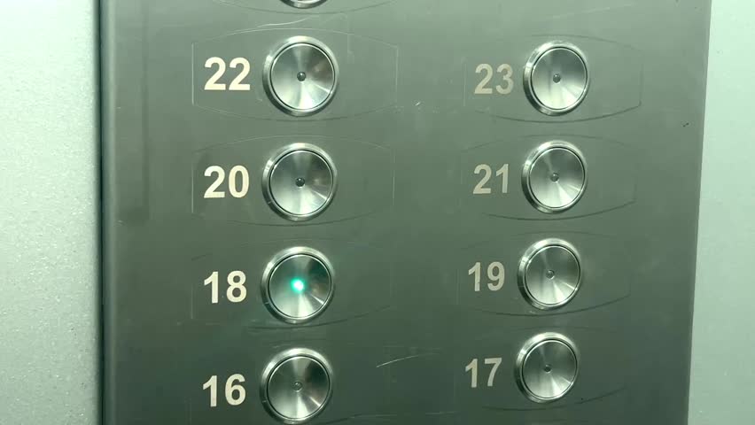 Close up of elevator control panel with illuminated floor buttons, modern building interface.