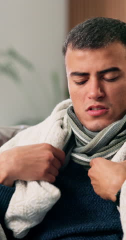 Sick, blanket and man with cough in home, respiratory infection and viral disease for fever symptoms. Cold, congestion and person with pneumonia for discomfort, flu virus or winter season for illness