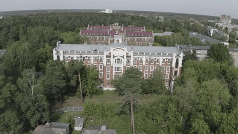 Drone Flying Forward above Forest Buildings