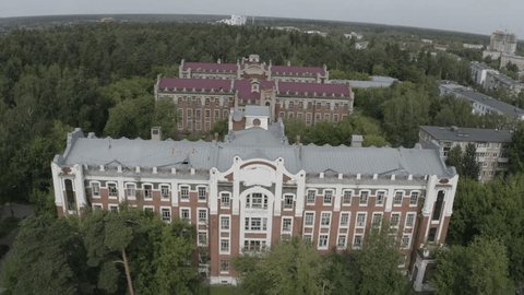 Aerial Backward Ascent over Old Buildings Forest
