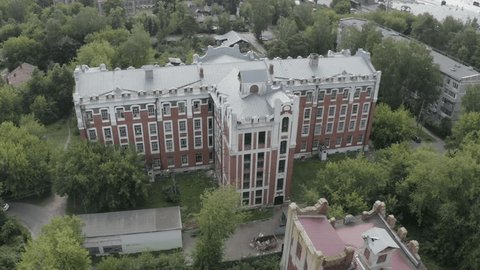 Drone Orbiting Historic Brick Building above Trees