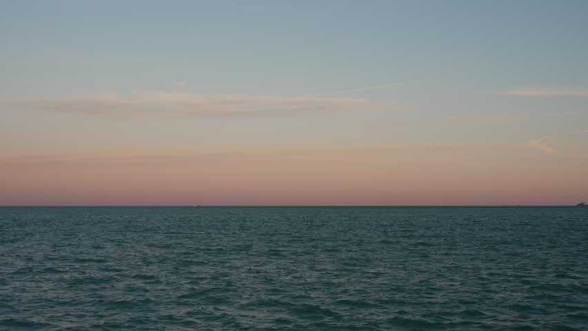 Peaceful view of Lake Michigan with soft waves and pastel sunset sky. Natural ambient audio of birds and light wind creates a relaxing atmosphere. Ideal for meditation, background, and nature scenes. 4K 30fps.
