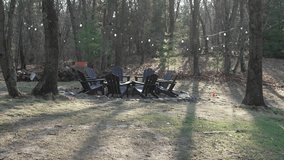 Cozy outdoor fire pit area with wooden chairs in a forest backyard during soft morning light. Natural ambient audio with birds singing creates a peaceful and relaxing atmosphere. 4K 30fps. - Powered by Shutterstock - Get 15% off with code: PIKWIZARD15