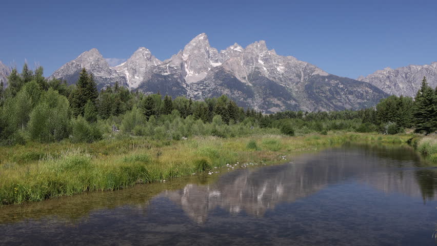 Teton Range reflecting in Snake River at Schwabacher Landing at Grand Teton National Park in Wyoming, USA 