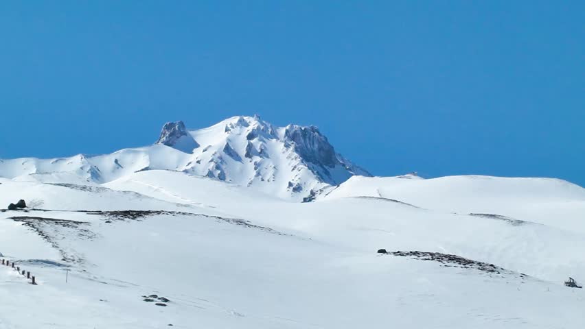 KAYSERI, TURKEY - MARCH 12, 2026: A majestic 4K cinematic wide shot of Erciyes Mountain (Mount Erciyes) in winter. The footage captures the iconic snow-capped volcanic peak standing alone against a clear sky. This professional stabilized gimbal footage showcases the grand scale and natural beauty of the Central Anatolian highlands, perfect for documentaries, travel films, and scenic backgrounds.
