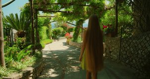 Tourist woman walking under shaded garden pathway in Capri Italy on summer day - Powered by Shutterstock - Get 15% off with code: PIKWIZARD15