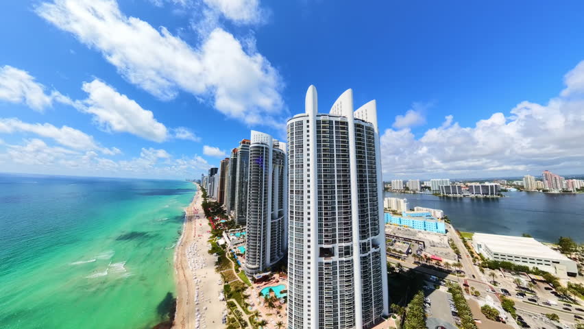 Aerial video tracking highrise buildings drone turns from front view to rear view pull out shot