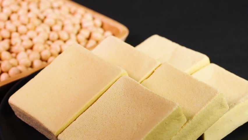 Dried freeze-dried tofu and soybeans on rotating plate against a black background