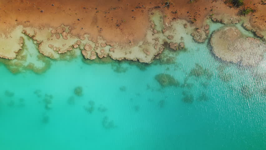 Aerial of rocky stromatolite shoreline and turquoise clear water of lagoon