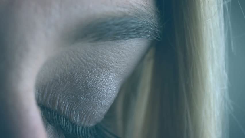 Woman opening eye while magenta particle sweeping, causing green code scrolling over iris for tech. Closeup, portrait, gaze, holographic, overlay, neon, digital
