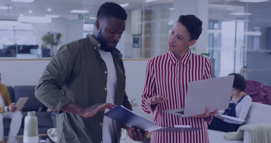 Office pair reviewing folder and laptop with woman pointing, working on tech as green code streams. Collaboration, teamwork, documents, devices, binary, lounge, modern