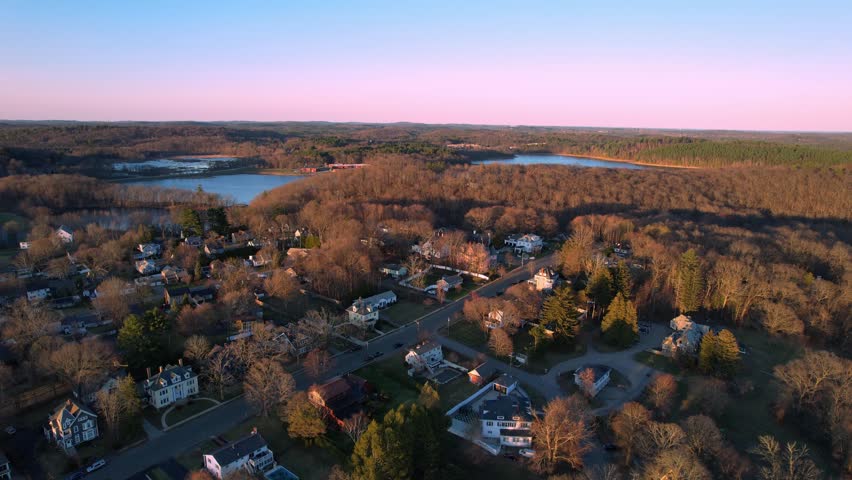 Aerial view of quiet New England neighborhood and leafless forest at dusk, Haverhill, Massachusetts, USA