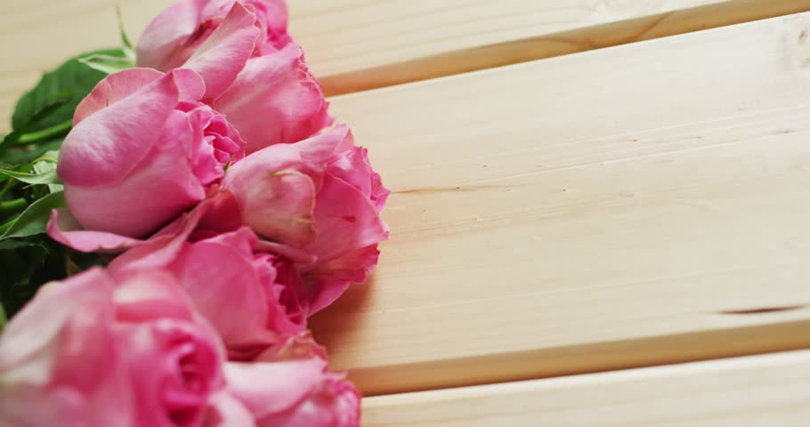 Bouquet of pink roses on wooden background at valentine