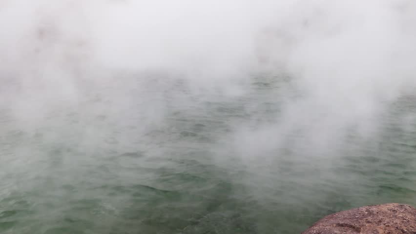 White steam rising from the hot spring