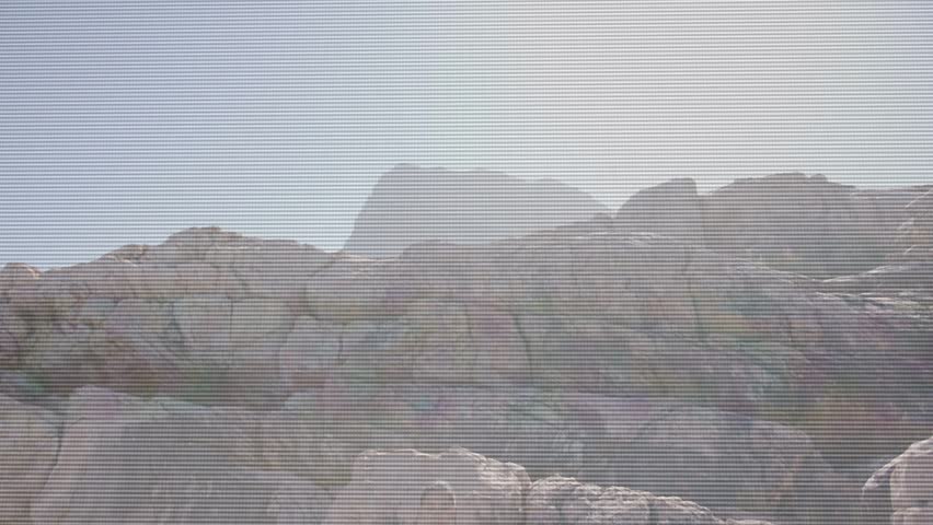 Woman emerging behind rock ledge and sitting, resting while butte and scrub highlighting geology. Desert, sandstone, canyon, arid, silhouette, hiker, backlit