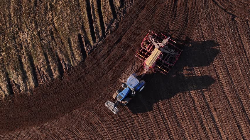 The tractor cultivates the field