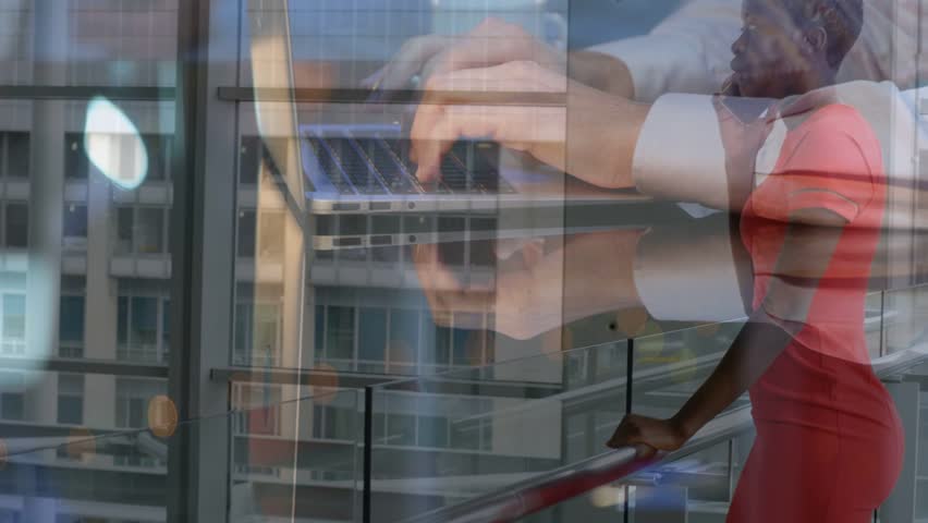 Woman raising phone to ear, speaking while typing hands overlay laptop coordinating business call. Office, atrium, female, red, dress, smartphone, glass
