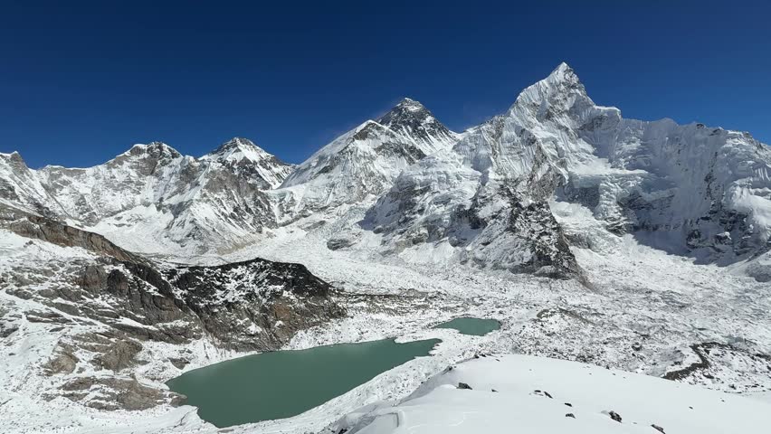 Smooth camera movement over Mount Everest and surrounding Himalayan peaks from Kala Patthar, Nepal. Panoramic view of valley, glacier and Everest Base Camp in clear sunny weather