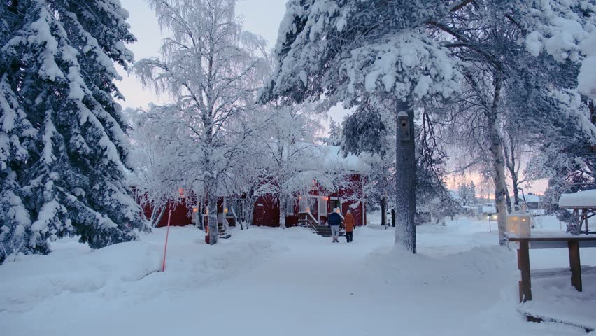 Explore the enchanting village of Akaslompolo in Lapland, Finland, blanketed in snow. Frost-covered trees and warm cabins create a magical winter atmosphere.