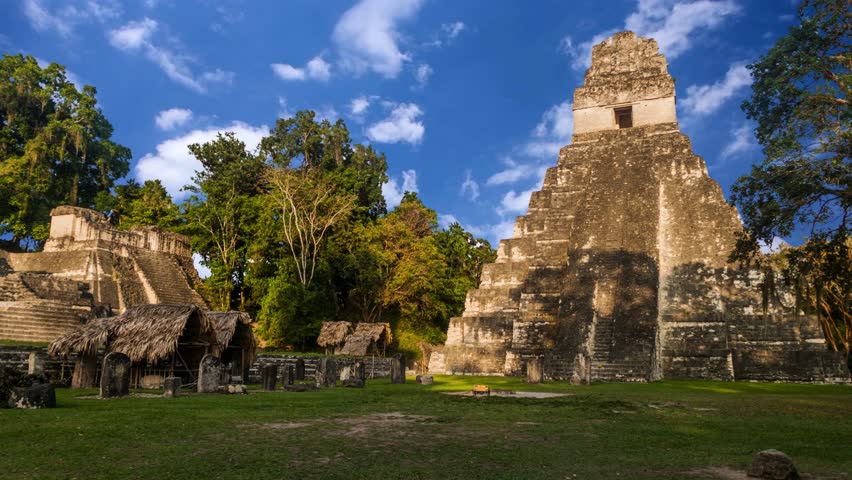 Explore the ancient Mayan ruins of Tikal under the vibrant sky in Guatemala, showcasing the Temple I pyramid surrounded by lush greeneryMayan Temple I (Gran Jaguar) at Tikal National Park - GuatemalaPanoramic view of the Great Plaza in the maya site of Tikal, Guatemala