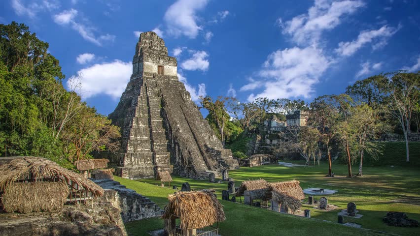 Explore the ancient Mayan ruins of Tikal under the vibrant sky in Guatemala, showcasing the Temple I pyramid surrounded by lush greeneryMayan Temple I (Gran Jaguar) at Tikal National Park - GuatemalaTikal, the ruin of an ancient city, which was likely to have been called Yax Mutal, found in a rainforest in Guatemala.