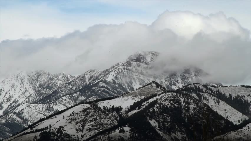 Timelapse of snow covered mountains and dramatic clouds moving near Bozeman Montana