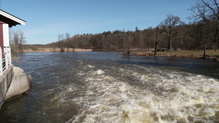 A powerful rapid of water next to a house