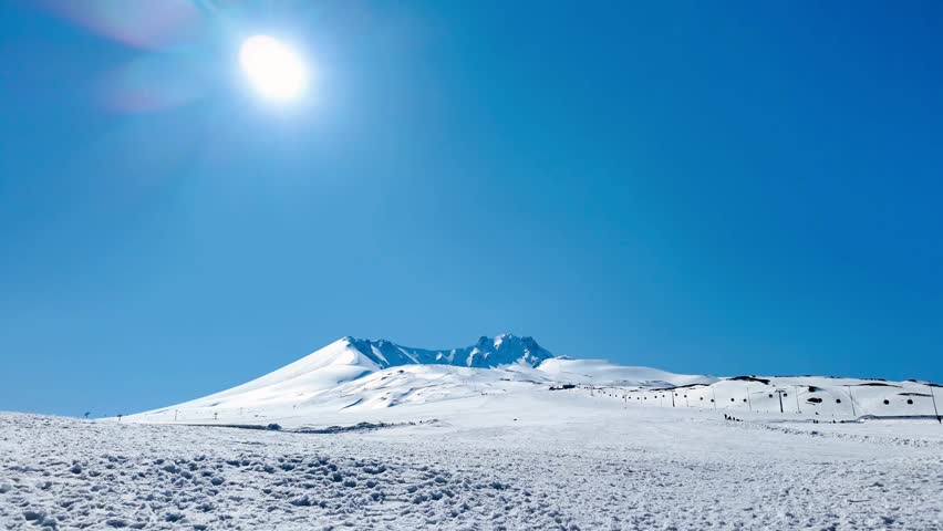 KAYSERI, TURKEY - MARCH 12, 2026: A majestic 4K cinematic wide shot of Erciyes Mountain (Mount Erciyes) in winter. The footage captures the iconic snow-capped volcanic peak standing alone against a clear sky. This professional stabilized gimbal footage showcases the grand scale and natural beauty of the Central Anatolian highlands, perfect for documentaries, travel films, and scenic backgrounds.
