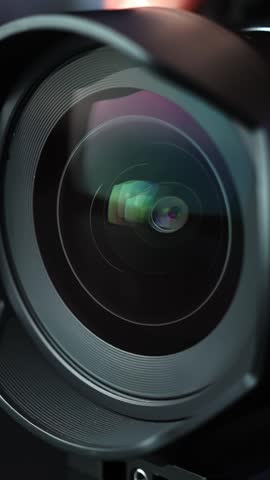 Macro close-up of a wide-angle camera lens as the aperture iris smoothly closes and opens, with glossy glass reflections and cinematic light flare—perfect for tech and film intros.