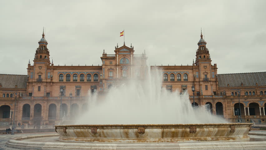 Water fountain in foreground with Plaza de España architecture behind, highlighting symmetry, historic design, and iconic landmark in Seville, Spain. Grand and epic location.