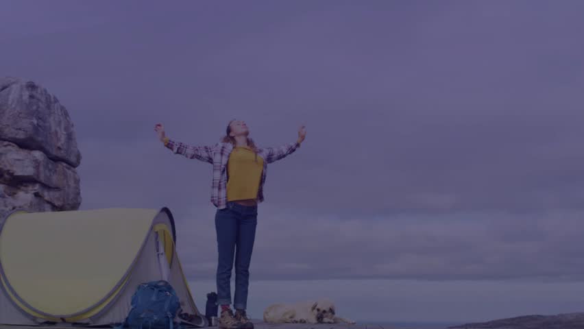 Holographic map activating, woman hiker raising arms, looking up and interacting with travel UI. Outdoor, campsite, traveler, futuristic, ar, interface, overlay