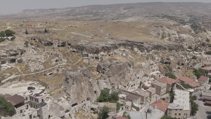 Urgup, Nevsehir, Turkey. Abandoned rock dwellings with enclosed courtyard and traditional stone fence in Cappadocia landscape. Aerial View