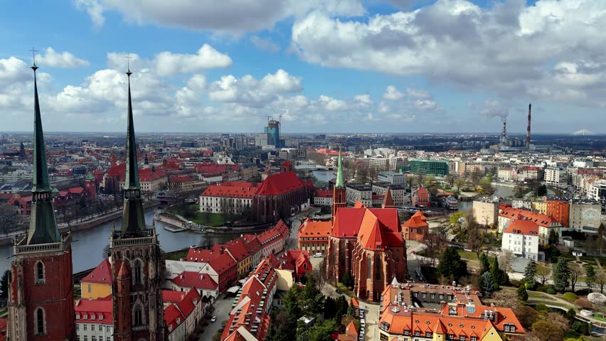 Panoramic view of Wroclaw, Poland, featuring the Cathedral of St. John the Baptist and historic red-roofed architecture, Ostrów Tumski island, Odra river, city skyline, sunny day.