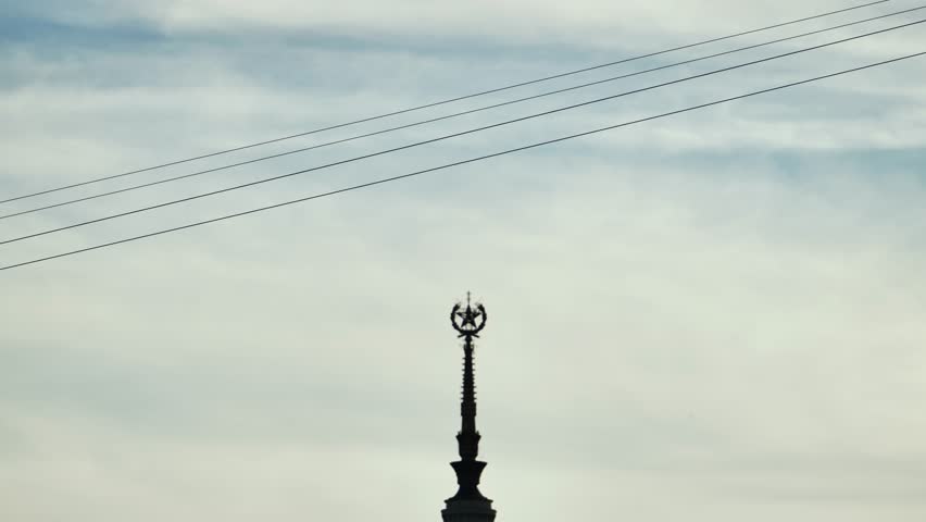 Person ziplining across sky, adventure sport with urban landmark visible below