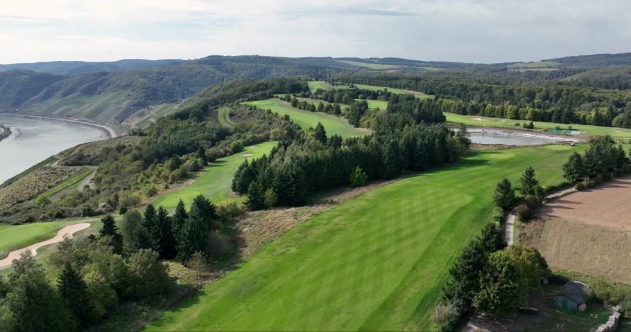 Aerial view of the Golfclub Jakobsberg, with its lush green fairways, tranquil ponds, and the meandering river in the distance, Braubach, Germany.