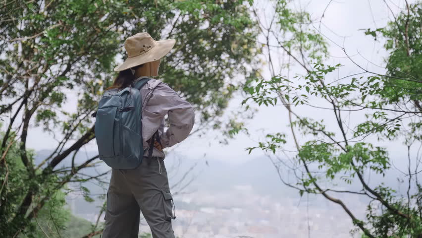 Active lifestyle hiker backpacker tourist with backpacks reaching up top of mountain, victoriously outstretching raised arms up and jumping up, successful climber celebrating success on mountain peak