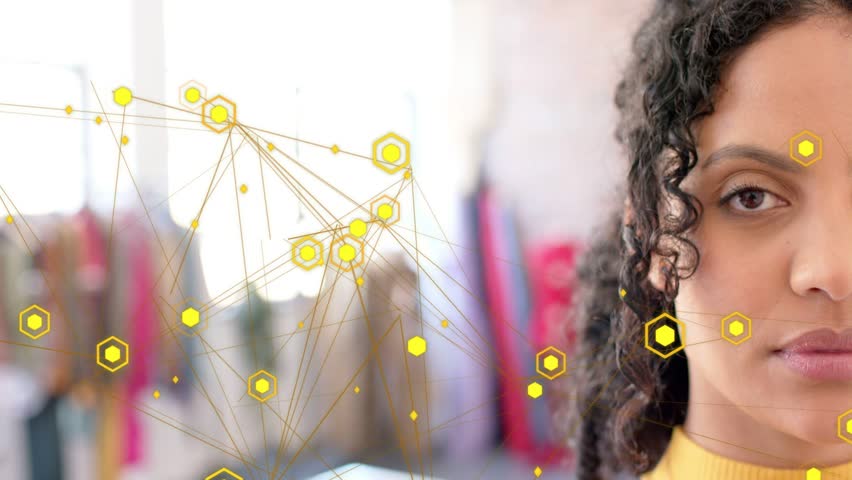 Adult female responding to animated yellow hex nodes drifting across boutique scene with big smile. Woman, fashion, boutique, retail, garments, sweater, window